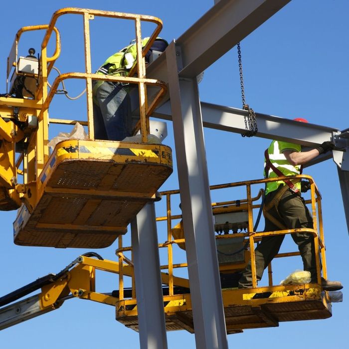 workers lifted into the air securing metal into place