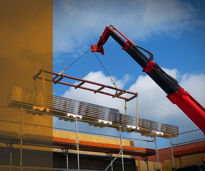 red crane lifting building materials