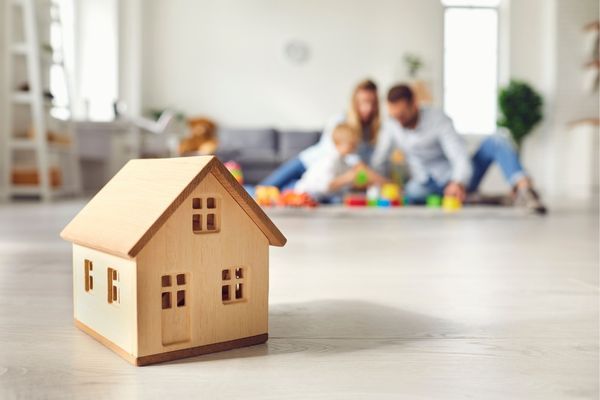 Model home in front of family playing