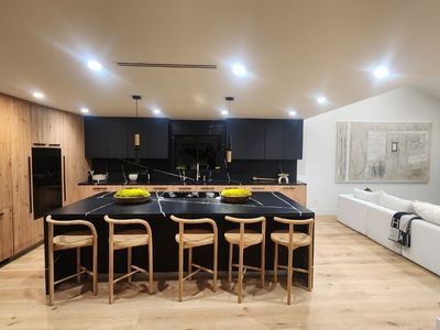 Newly renovated kitchen with black marble island and black cabinets