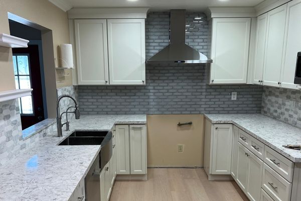 Newly renovated kitchen with light cabinets and white granite countertops