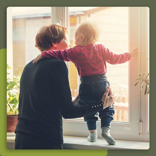 Grandparent with child looking out window