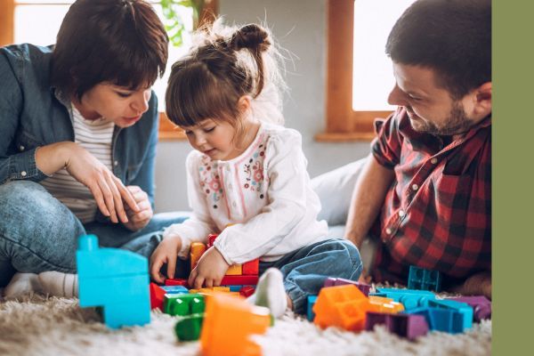 mom, dad, and daughter playing with toys