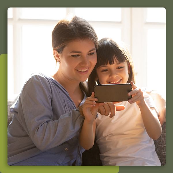 Mom watching a video on a phone with her daughter