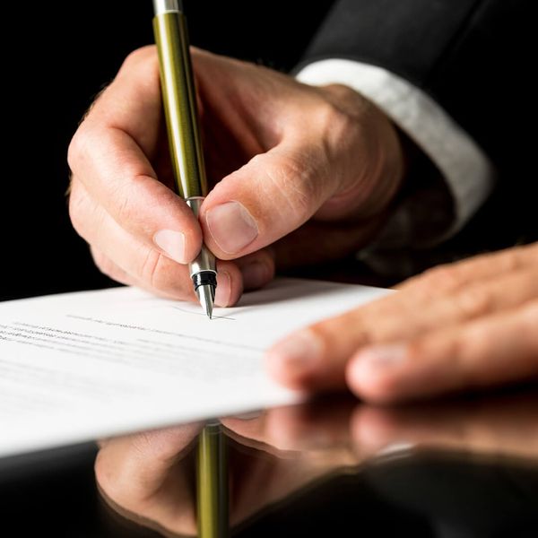 Professional stock image of a close-up of hands reviewing legal paperwork, with a focused and serious expression, symbolizing the detailed requirements of adoption. No text or words. legalrequirements.jpg