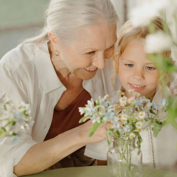 a grandmother and granddaughter looking at beautiful flowers grandparent.jpg