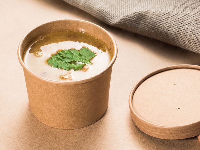 Compostable Kraft soup container holding warm soup