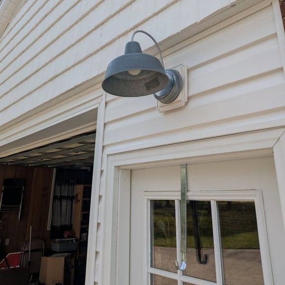 Rustic outdoor light fixture installed above garage entry door in Pleasant Garden NC