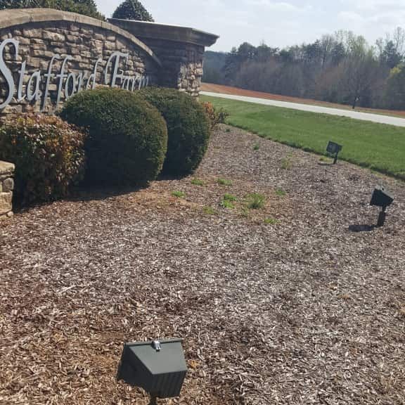 Three landscape flood lights illuminating an outdoor neighborhood sign in Oak Ridge NC