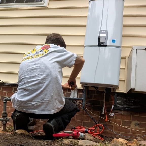 Licensed electrician installing outdoor GFCI outlet at tankless water heater in Madison NC
