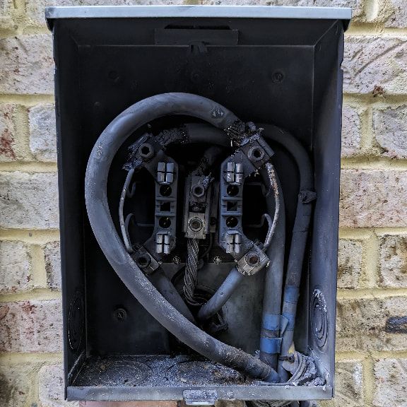 Burnt residential meter base from electrical fire