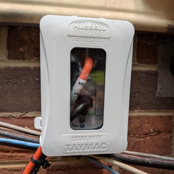 Weatherproof outdoor GFCI outlet with cords connected in Madison NC