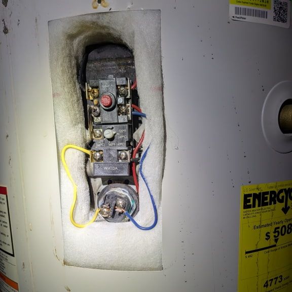 Electrician inspecting water heater thermostat and heating element during emergency service in Pleasant Garden NC