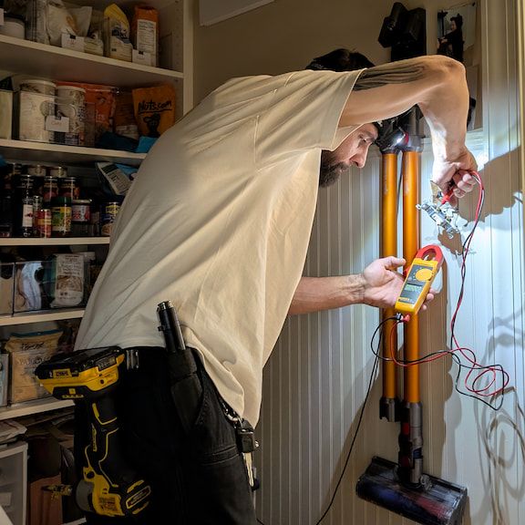 Electrician diagnosing light switch electrical issue in Summerfield, North Carolina home