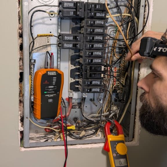 Emergency electrician troubleshooting breaker panel with multimeter