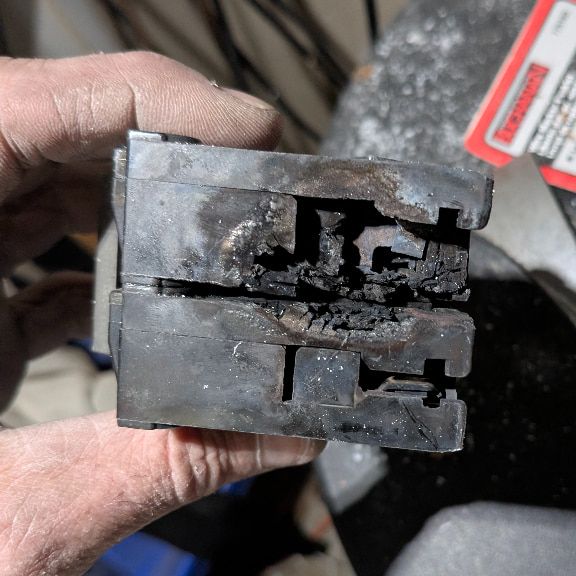 Burned double-pole circuit breaker with visible damage