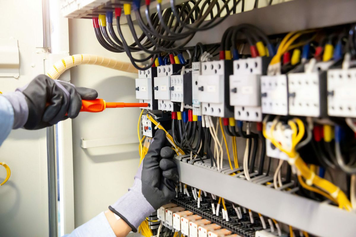 Electrician working on electrical control modules and wiring