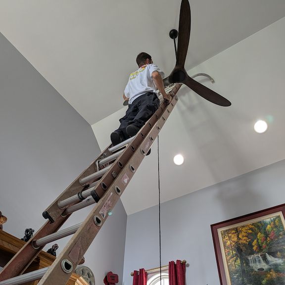 Licensed electrician installing ceiling fan in Summerfield, North Carolina home