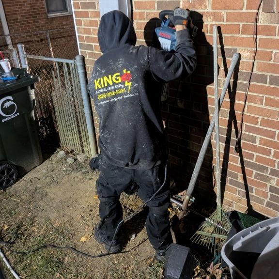 Electrician performing storm damage repair at night