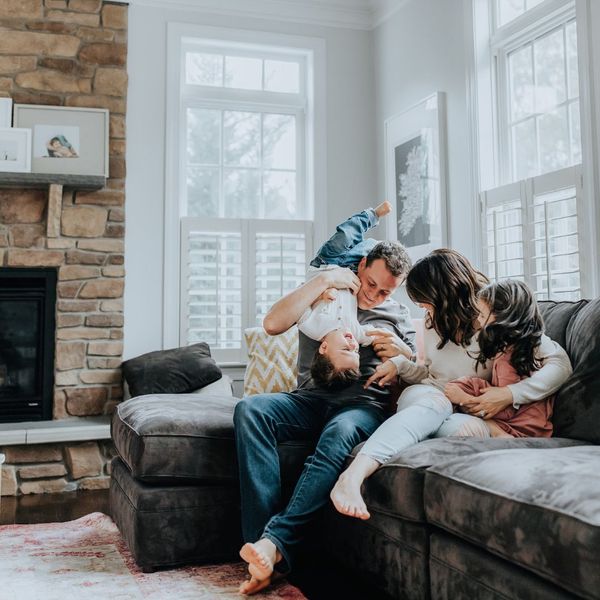 a family rough housing on the couch