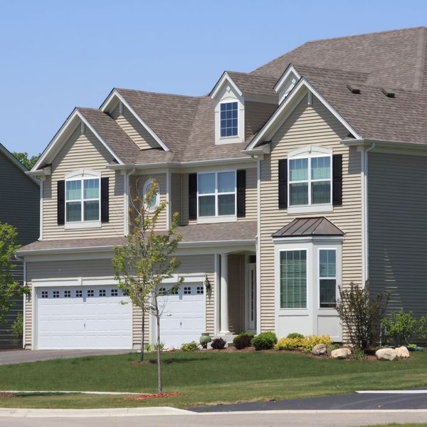 a tall tan house in a neighborhood