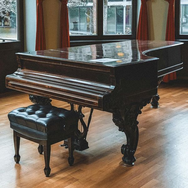 A grand piano and bench in a large open room