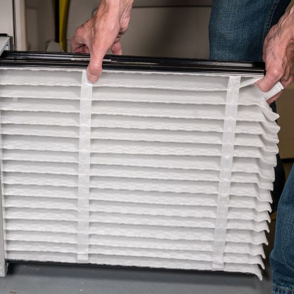 Technician putting in new filter into a unit How to Choose the Right Air Filters for Your HVAC System2.jpg