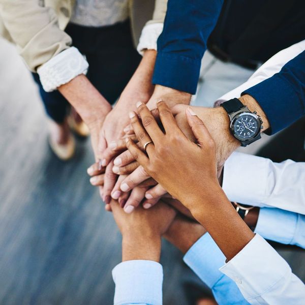 Several people with hands stacked on top of each other.