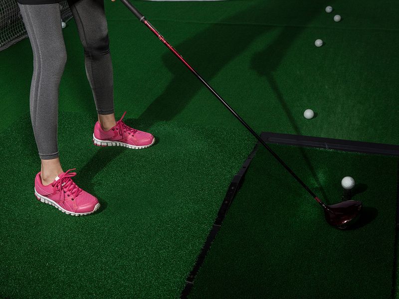 close up of woman practicing in golf simulator