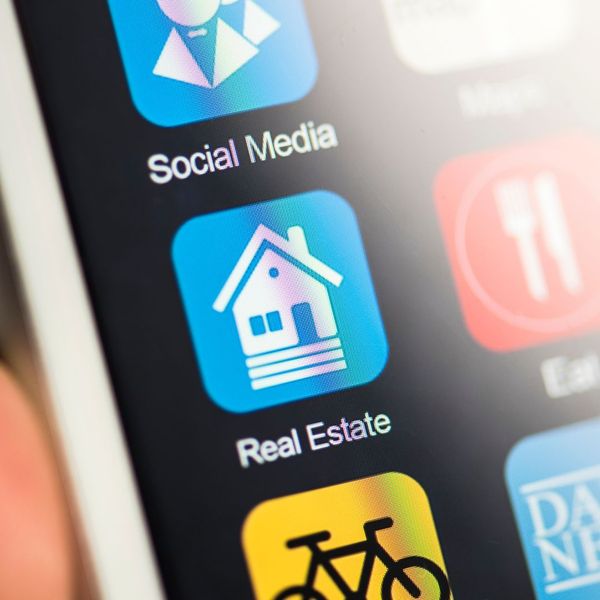 Phone with apps and a close of an app called "Real Estate."