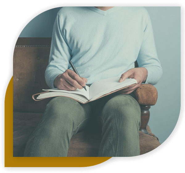 man writing in journal