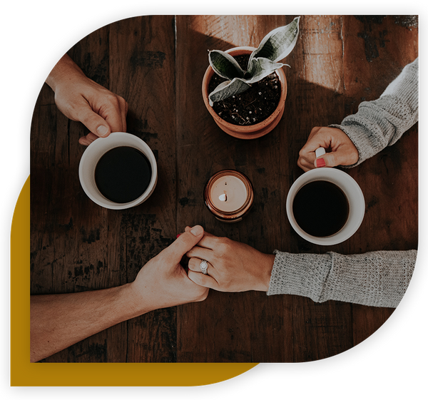 Couple holding hands over coffee