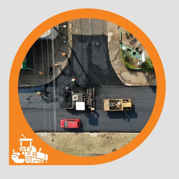 An aerial shot of an asphalt crew laying fresh pavement on a road