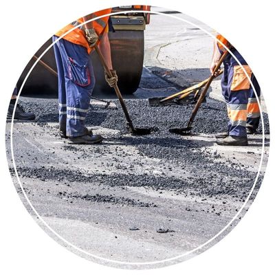 Workers spreading hot asphalt on a road surface