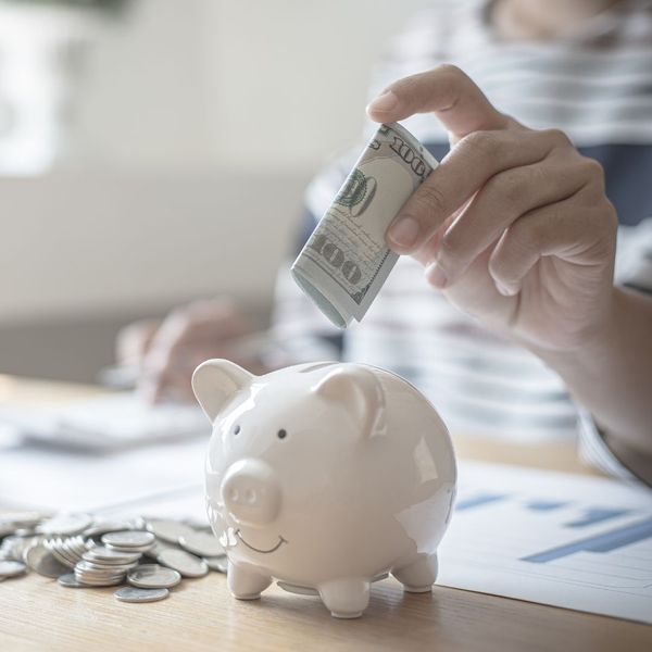 Money being placed into a piggy bank