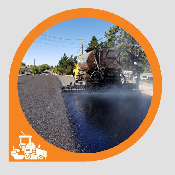 An asphalt paving truck laying a fresh layer on a street