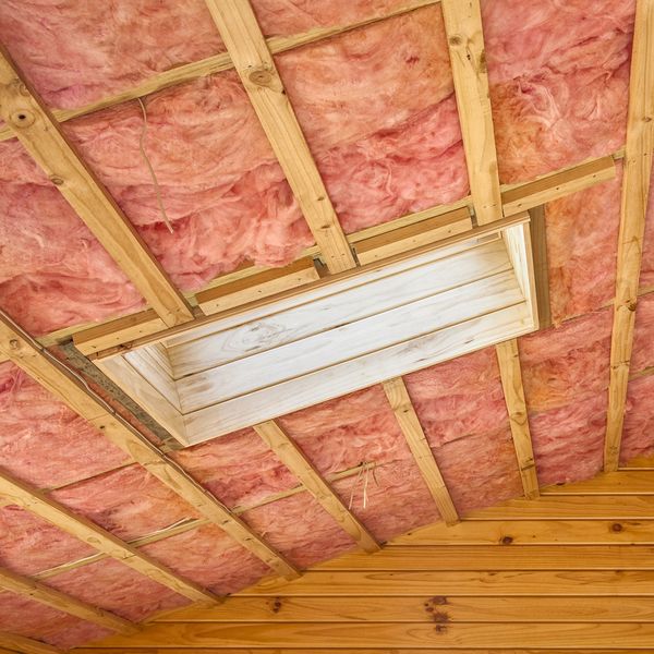 thick fiberglass insulation into an attic space.