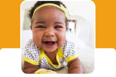 infant smiles while laying on tummy 