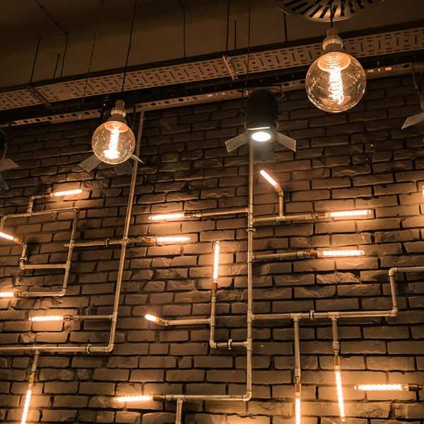 Industrial-Style Brick Wall Lighting Installation with Conduit