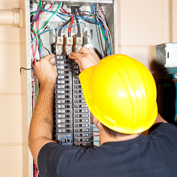 Electrician Installing Circuit Breakers in an Electrical Panel