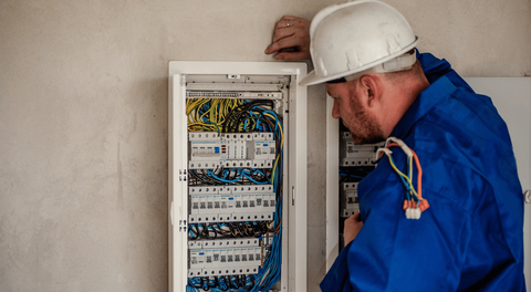 A focused shot of an electrician inspecting a residential electrical panel with a flashlight, looking for potential hazards or issues. The scene should convey thoroughness and safety. A focused shot of an electrician inspecting a residential electrical panel with a flashlight, looking for potential hazards or issues. The scene should convey thoroughness and safety.