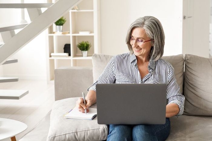 Person sitting on a couch and using a laptop