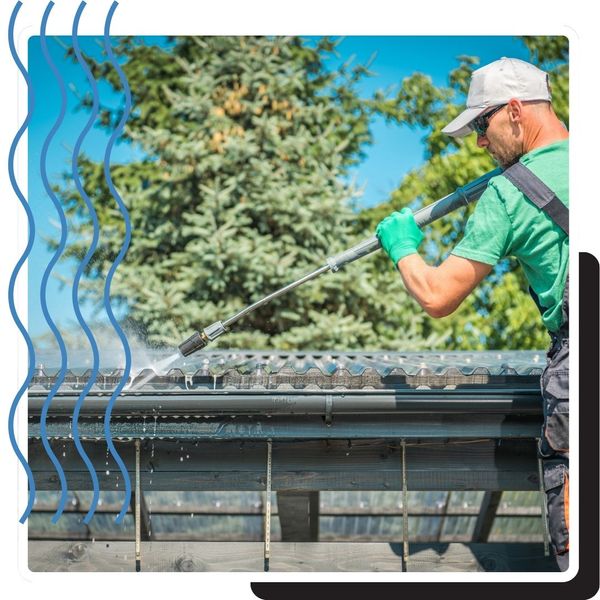 man pressure washes a gutter clean