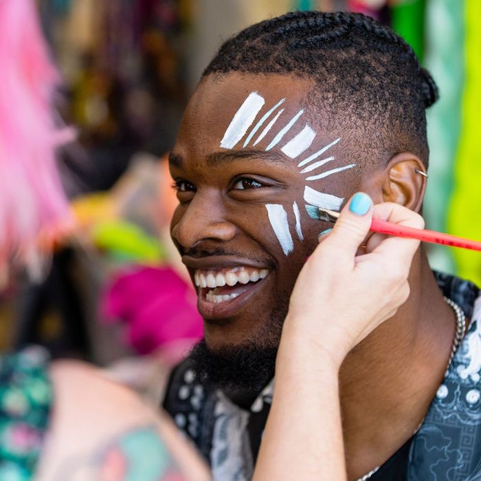 person getting face painted at a festival