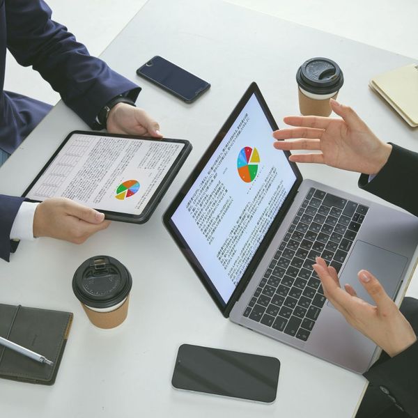 business discussion over laptop/tablet showing pie charts