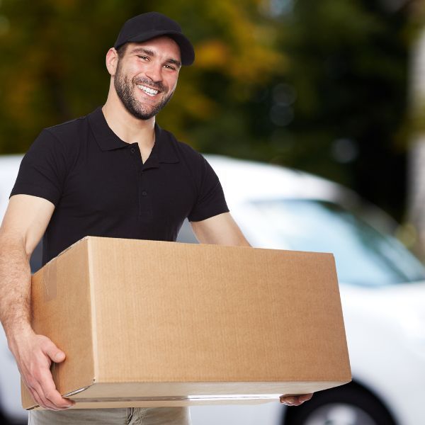 Man holding moving box and smiling