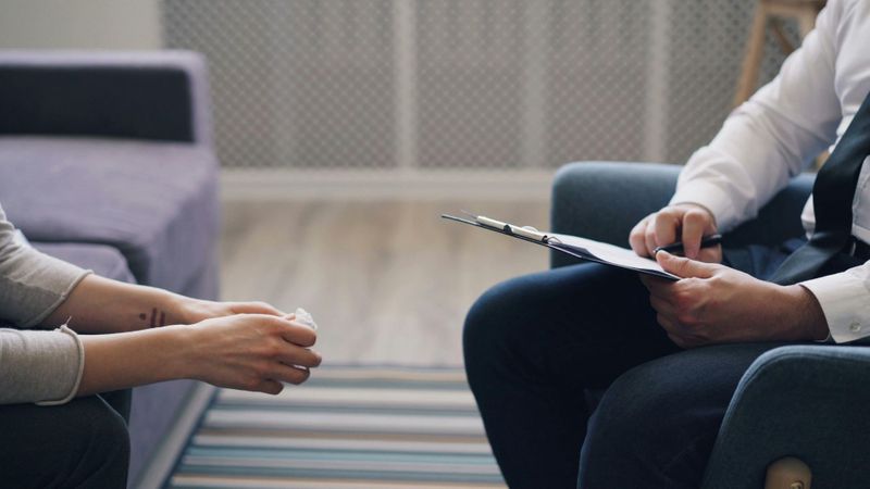 Counselor talking with a person holding a tissue