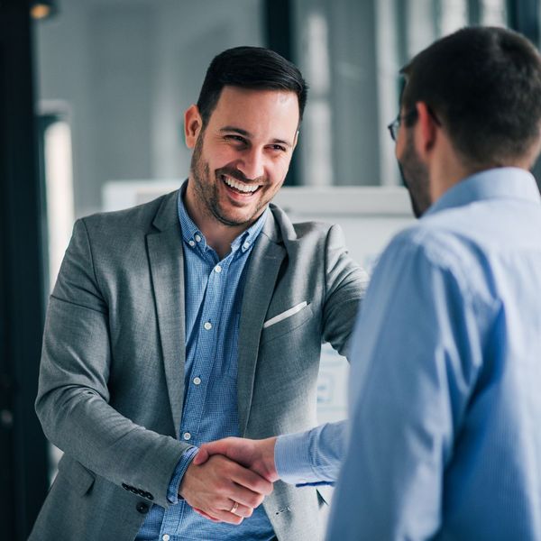 Portrait of cheerful young manager handshake with new employee.