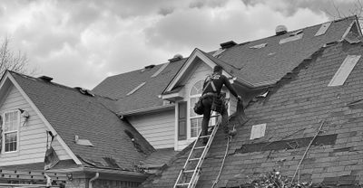 Storm restoration crew member working on a damaged roof