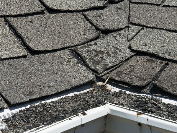 Old bad and curling roof shingles on a house. 